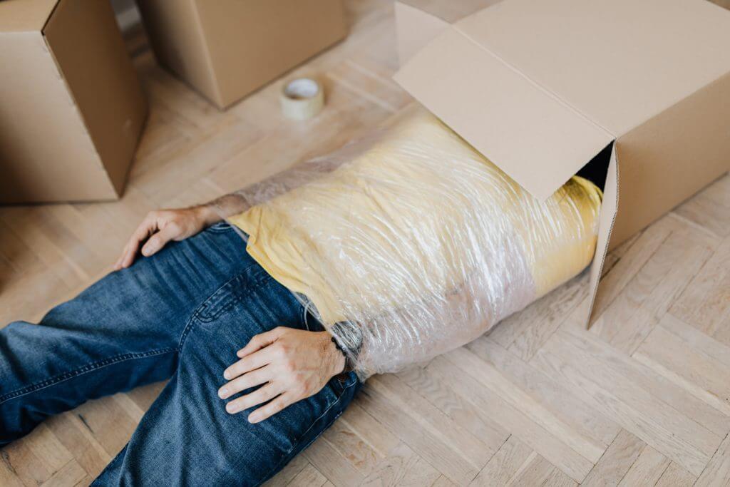 Man in plastic wrap and box