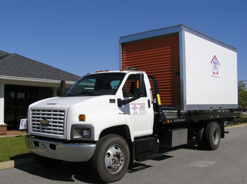 Mobile Attic Truck with red door in front of house