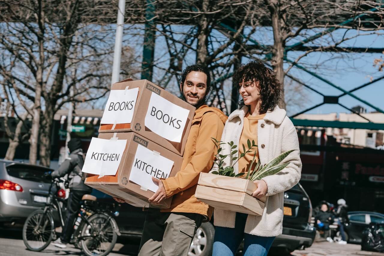 People Carrying Labeled Boxes in City