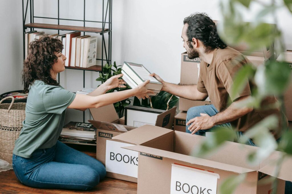 Man and Woman with Book Moving Boxes